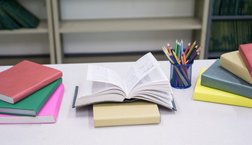Image of Pile of books and stationery at library. Education concept.